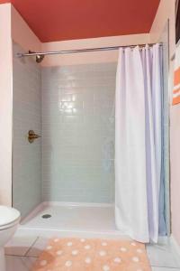a bathroom with a shower curtain and a toilet at Blush And Bashful Germantown Two Bedroom Apartment in Louisville