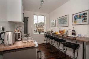 a kitchen with a counter top with stools in it at Trinity Square, Margate in Kent