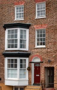 a brick building with a red door and white windows at Trinity Square, Margate in Kent