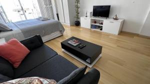 uma sala de estar com um sofá e uma televisão em Petite Maison II em Buenos Aires