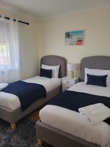 een slaapkamer met 2 bedden en blauwe kussens bij Sunset Lake View in Windang