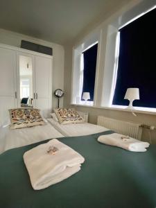 sypialnia z 2 łóżkami i ręcznikami w obiekcie Enjoy Reykjavík Yellow Door Apartment w Reykjavík