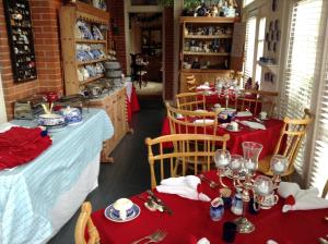a dining room with two tables with red tablecloths at 2439 Fairfield "A Bed and Breakfast" in Shreveport