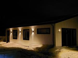 a building with lights on the side of it at night at Skidbakki Guesthouse 