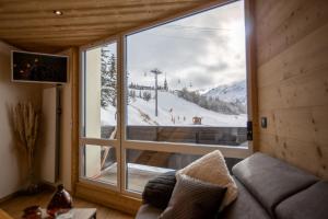 een kamer met een groot raam in een skilodge bij Duplex cosy au pied des pistes vue montagne in Les Menuires