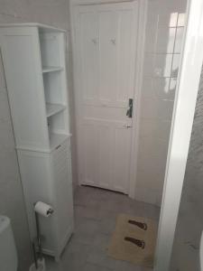 a white bathroom with a toilet and a door at Casita a la luz de la Alhambra II in Granada
