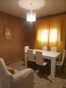 une salle à manger avec une table et des chaises blanches dans l'établissement Casita a la luz de la Alhambra II, à Grenade