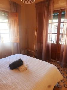a bedroom with a large white bed with windows at Casita a la luz de la Alhambra II in Granada
