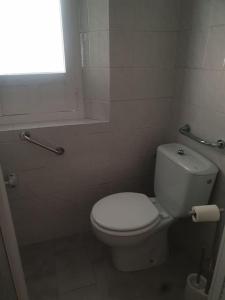 La salle de bains est pourvue de toilettes blanches et d'une fenêtre. dans l'établissement Casita a la luz de la Alhambra II, à Grenade