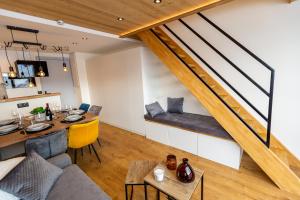 een woonkamer met een bank en een tafel bij Duplex cosy au pied des pistes vue montagne in Les Menuires