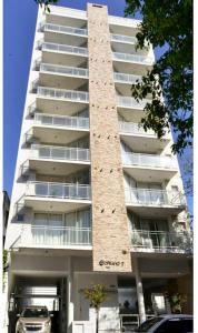 a tall building with a car parked in front of it at Departamento con cochera Mar del Plata in Mar del Plata