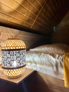 lampa na półce obok łóżka w obiekcie Sunshine House w Kutaisi