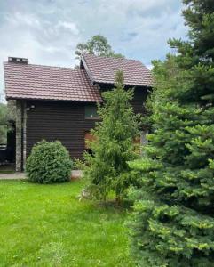 una casa con dos pinos delante en Green Villa Brezovica, en Štrpce