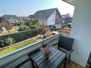 a balcony with a wooden table and chairs and a view at Süße, komfortable Wohnung - 52qm mit Parkplatz in Rietberg