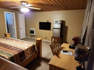 Schlafzimmer mit einem Bett, einem Schreibtisch und einem TV in der Unterkunft Eagle Nest Fly Shack & Lodge in Eagle Nest