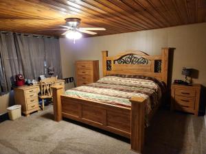 1 dormitorio con cama de madera y ventilador de techo en Eagle Nest Fly Shack & Lodge en Eagle Nest