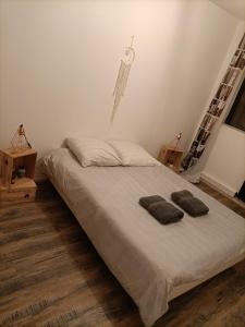 a bedroom with a bed with two pillows on it at Charmant appartement spacieux avec 3 chambres in Agen
