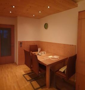 een eetkamer met een houten tafel met stoelen bij Alpen Appart Bludenz City in Bludenz
