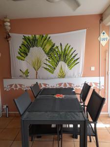 une salle à manger avec une table et des chaises noires dans l'établissement MANOU, à Sainte-Anne