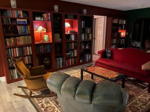 a living room with a couch and chairs and book shelves at Phantom History House Castle Room in Tampa