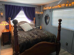 1 dormitorio con 1 cama y una ventana con cortinas moradas en Phantom History House Castle Room en Tampa