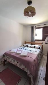sypialnia z dużym łóżkiem i fioletowym kocem w obiekcie Apt Recanto dos Golfinhos-Centro de Pipa w mieście Pipa