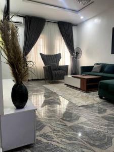 uma sala de estar com um sofá e um vaso em Beautiful 2Br Apt in Ogba, Ikeja, Lagos em Lagos