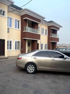 un coche aparcado en un aparcamiento frente a un edificio en Beautiful 2Br Apt in Ogba, Ikeja, Lagos en Lagos