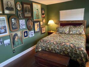 a bedroom with a bed and a bunch of pictures on the wall at Phantom History House - Portrait Room in Tampa