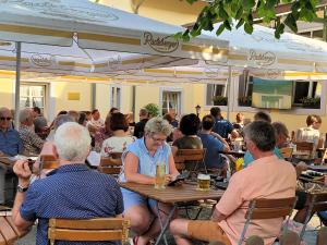 a group of people sitting at tables in a restaurant at Hotel Alttolkewitzer Hof in Dresden