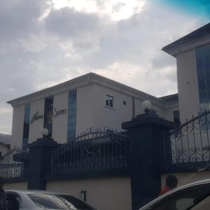 a white building with a balcony with cars parked in front at Haven Suites, Ikenegbu in Owerri