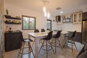 una cocina con mesa y algunas sillas. en Le Palmiste lovely 2-bedroom duplex with pool, en Grand Gaube