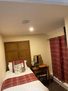 a bedroom with a bed and a desk with a mirror at The Bell Inn in Salisbury