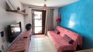 a living room with a red couch and a blue wall at Apt Recanto dos Golfinhos-Centro de Pipa in Pipa