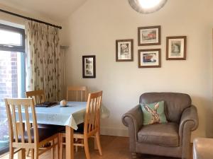 a dining room with a table and a chair at Rustys Cottage in Skirpenbeck