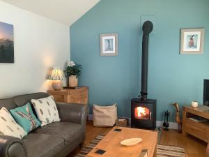 a living room with a couch and a wood stove at Rustys Cottage in Skirpenbeck