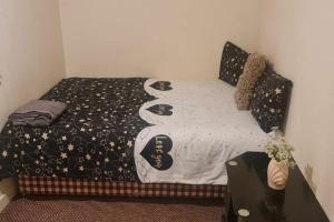 a bedroom with a bed with a black and white comforter at Modern flat in Jerviston Court in Motherwell