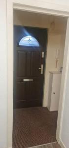 a black door with a window on it in a hallway at Modern flat in Jerviston Court in Motherwell