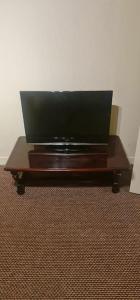 a television on a wooden table in a room at Modern flat in Jerviston Court in Motherwell