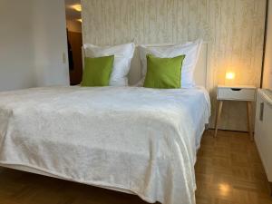 a bedroom with a large bed with green pillows at Ferienwohnung-Ludwigsburg-City in Ludwigsburg