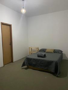 a bedroom with a bed and a chair and a door at Pousada vida nos lençóis in Barreirinhas