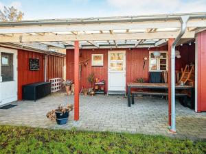 un patio con pérgola de madera y un banco en Holiday home Haderslev LIV en Haderslev