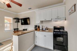 a kitchen with white cabinets and a black stove at Steps to the Beach and Restaurants! - Coconut Villa's Suite 1 in St. Pete Beach