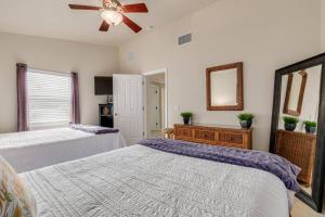 sypialnia z 2 łóżkami i wentylatorem sufitowym w obiekcie Steps to the Beach and Restaurants! - Coconut Villa's Suite 1 w St Pete Beach