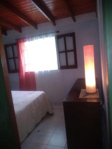 1 dormitorio con 1 cama y 1 lámpara en una mesa en Cabaña en las sierras de Cosquín en Cosquín