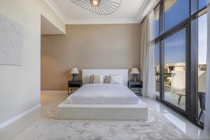 a bedroom with a white bed and a large window at Luxury 5-BR Villa Private Pool Golf Views in Dubai