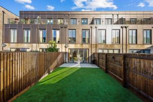 a house with a yard of green grass at Amazing new built townhouse with garden in London in Hendon