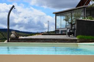 a swimming pool in front of a house at Casa de Alpajares - Guest House & Spa in Freixo de Espada à Cinta