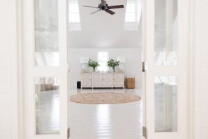 a whiteoyer with a ceiling fan and a table with plants at Conch Shell Harbour Island home in Harbour Island
