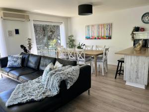 a living room with a black couch and a table at THE PHILLY in Cowes